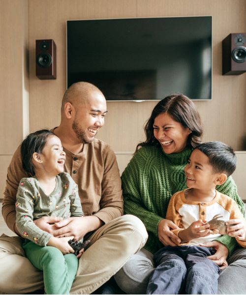 Family sitting on a couch together. Your healthiest days are ahead with Hyperbiotics family of products. 